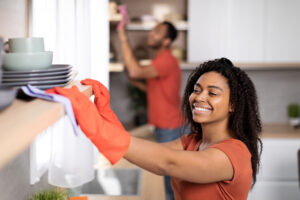 a professional cleaner with rubber gloves dusting shelves